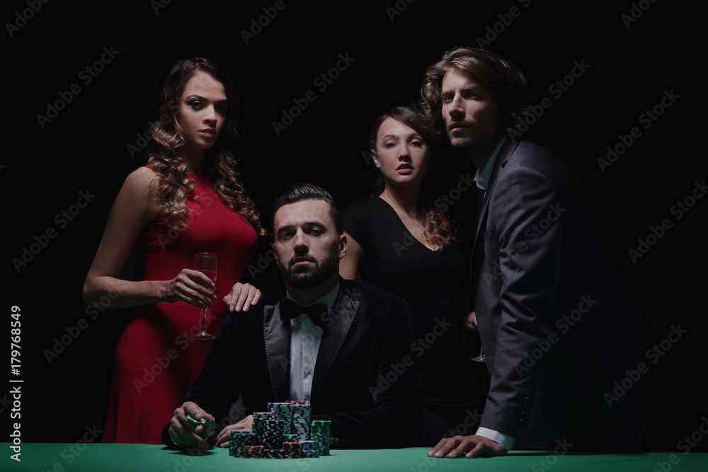 People standing at the table, looking, while a person is betting - obrazy, fototapety, plakaty 