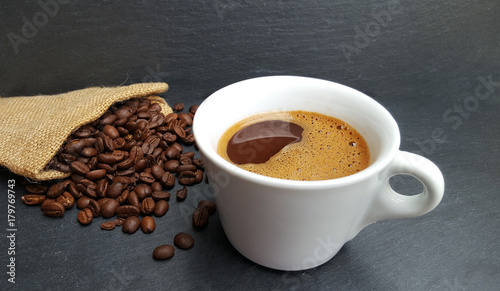 Coffee cup and beans on dark background