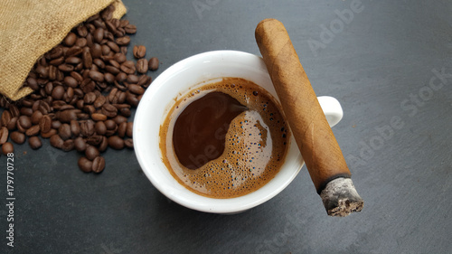 Coffee cup, beans and cigar  on dark  background