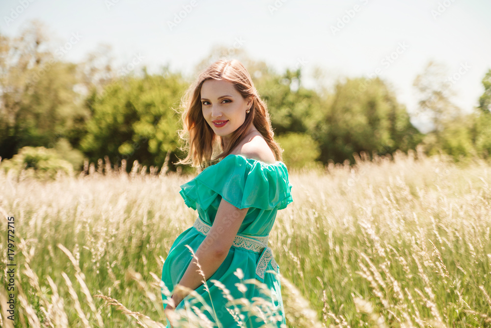 Beautiful young pregnant women in flowering meadow. Beautiful young pregnant women in flowering meadow.