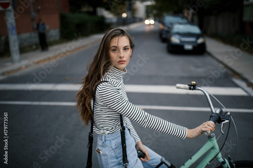 Portrait of young woman cycling on city street