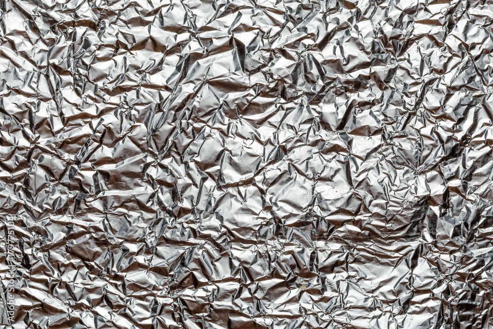 Crumpled shiny metal foil texture or background Crumpled shiny metal foil texture or background
