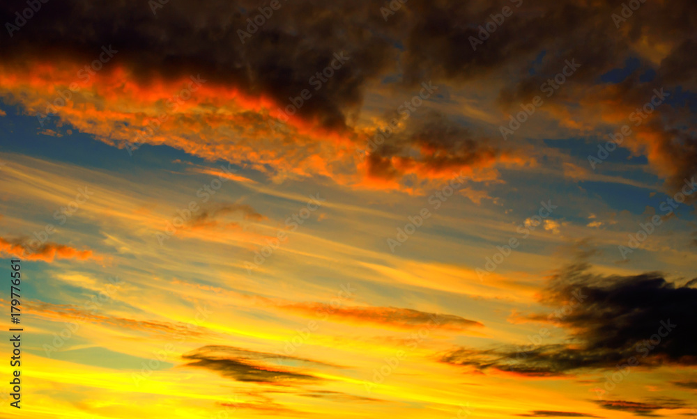 Photo of orange sunset with dark clouds on sky