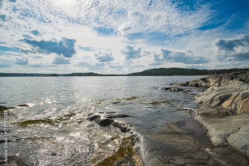 Landscape on a large lake with a stone beach on a summer day. Ladoga Lake, Karelia