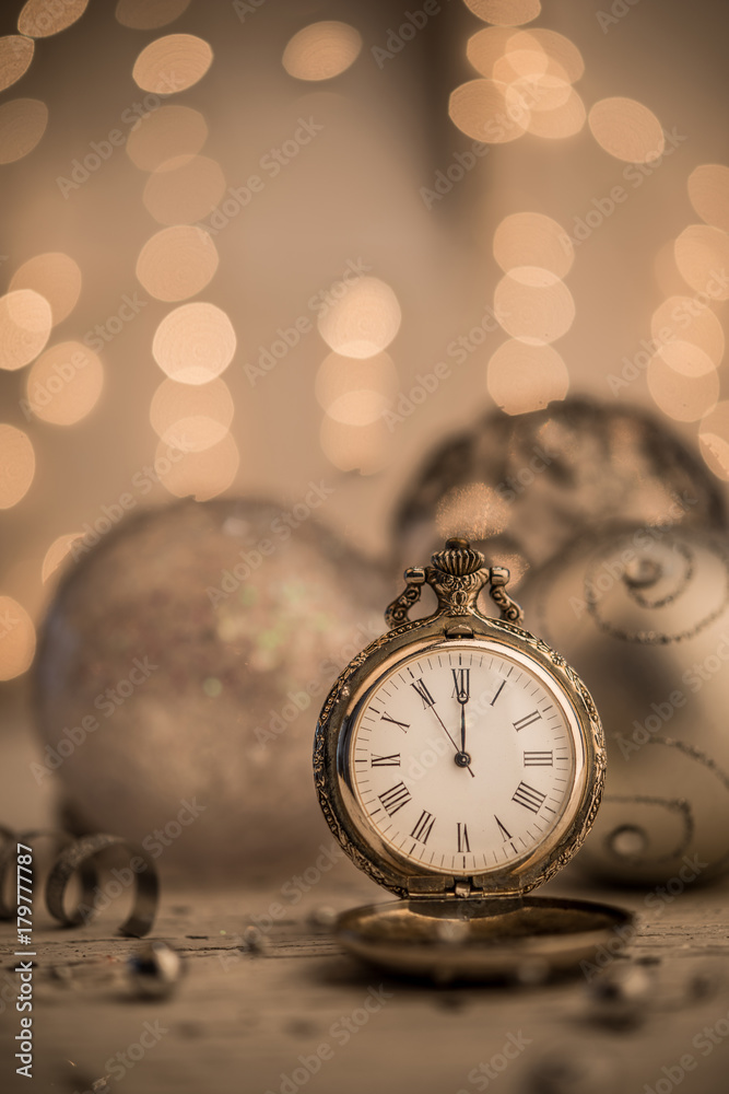 Gold new year pocket watch over sparkling lights background