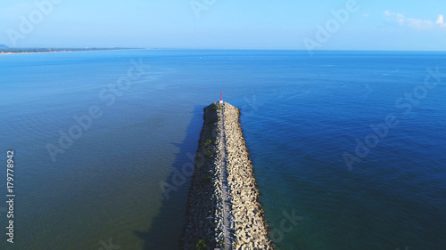 Aerial view. Perspective view of a wave breaker and light beacon in an island.