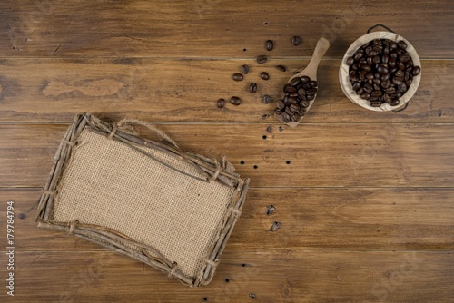 Coffee bean grain and sack fabrice board on brown wood table background , include copyspace for add text or graphic in advertise or marketing content photo