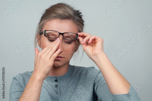 Tired woman has eyes pain. Optician and eyeglasses