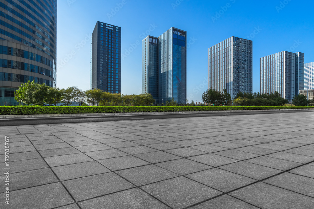 modern glass building exterior with empty pavement under blue sky, china