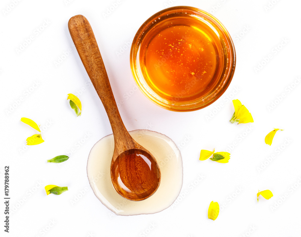Honey with jar and honey spoon and folwer isolated on white background Honey with jar and honey spoon and folwer isolated on white background