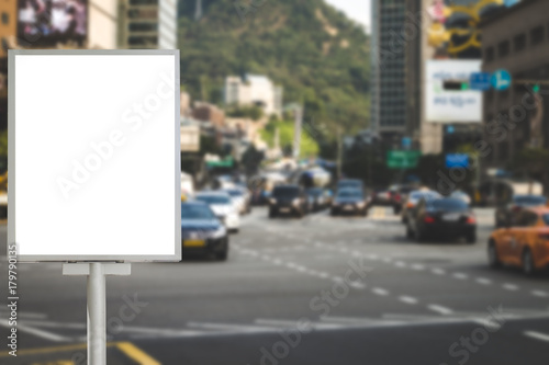 Blank billboard for information on bus stop beside the road, traffic road blurred background ,commercial, marketing and advertisement concept