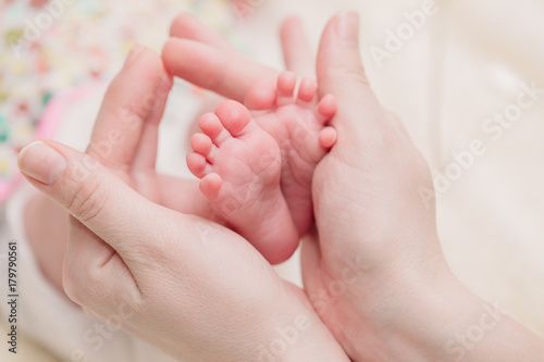 Mom holds small baby legs in hands © Zayne C.