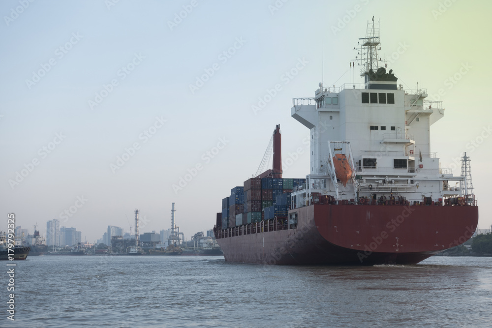 Tugboats assisting container cargo ship to harbor