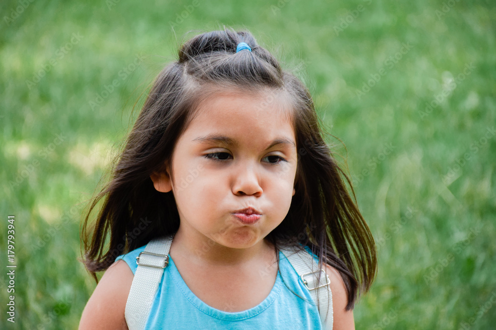 Little latin girl blowing her cheeks out. Little latin girl blowing her cheeks out.