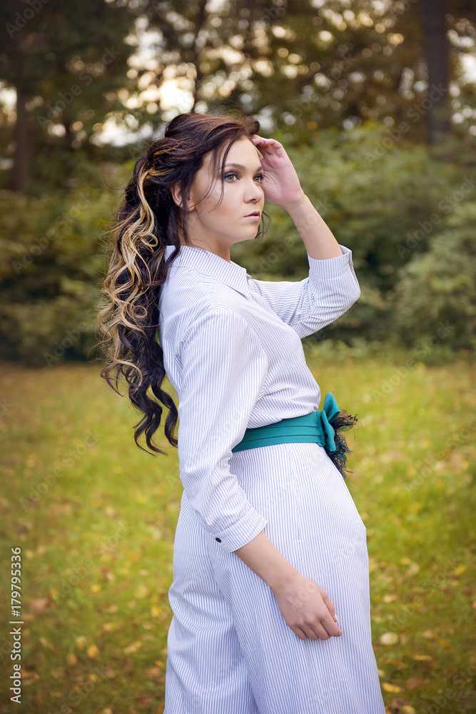 Fashion style portrait of a brunette in white dressed on nature background Fashion style portrait of a brunette in white dressed on nature background
