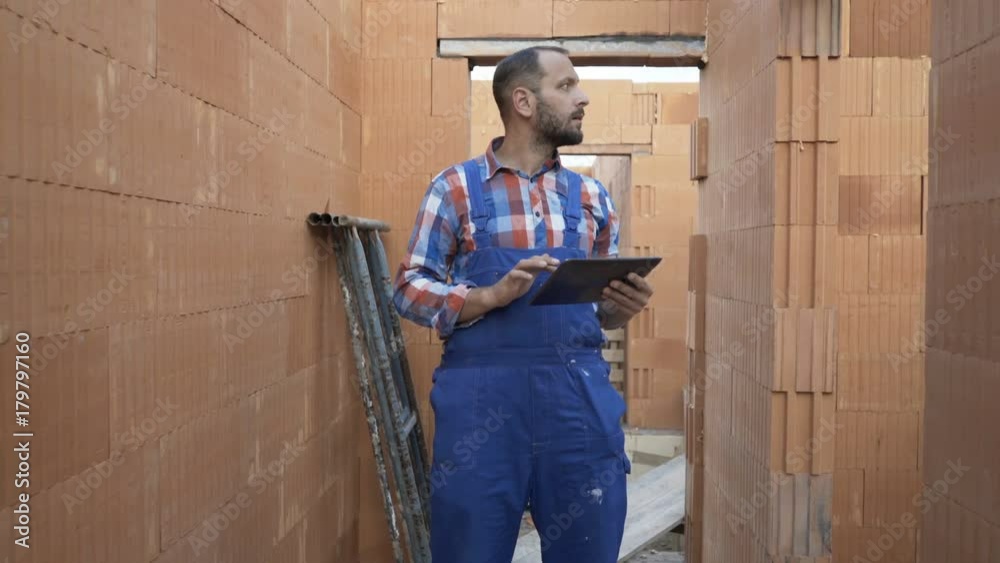 Young male worker with tablet checking home at construction site
Young male worker with tablet checking home at construction site