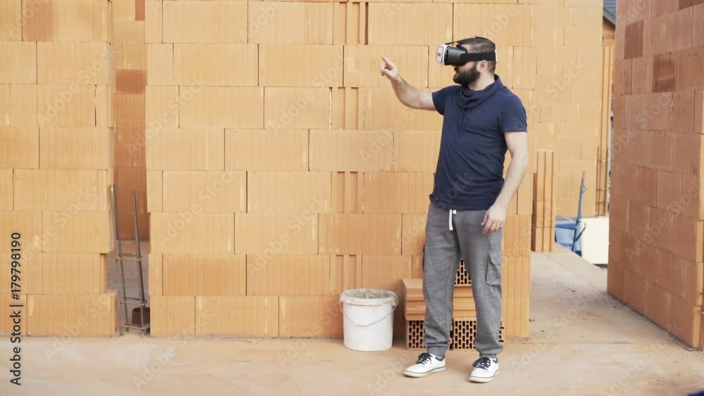 Man with vr goggle setting up visual project of new home at construction site
Man with vr goggle setting up visual project of new home at construction site