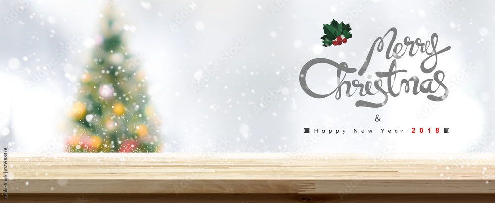 Naklejka premium Wood table top with blurred christmas tree and snow fall