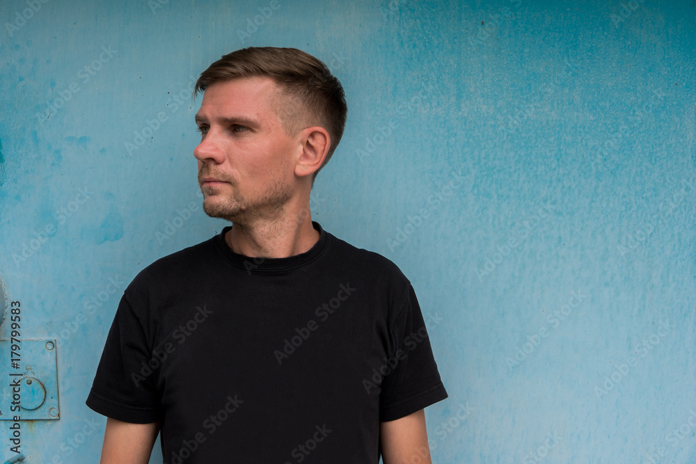 Man near blue metallic wall. Young european man at the street Man near blue metallic wall. Young european man at the street