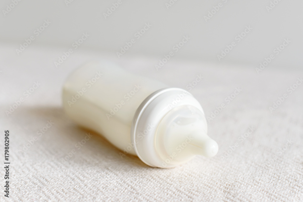 Bottle of milk for baby over blurred background Bottle of milk for baby over blurred background