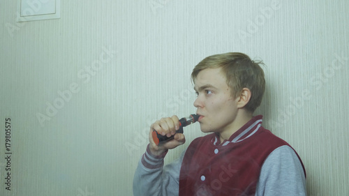 Young man smoking electronic cigarette. Young Man Using Vapourizer As Smoking Alternative photo