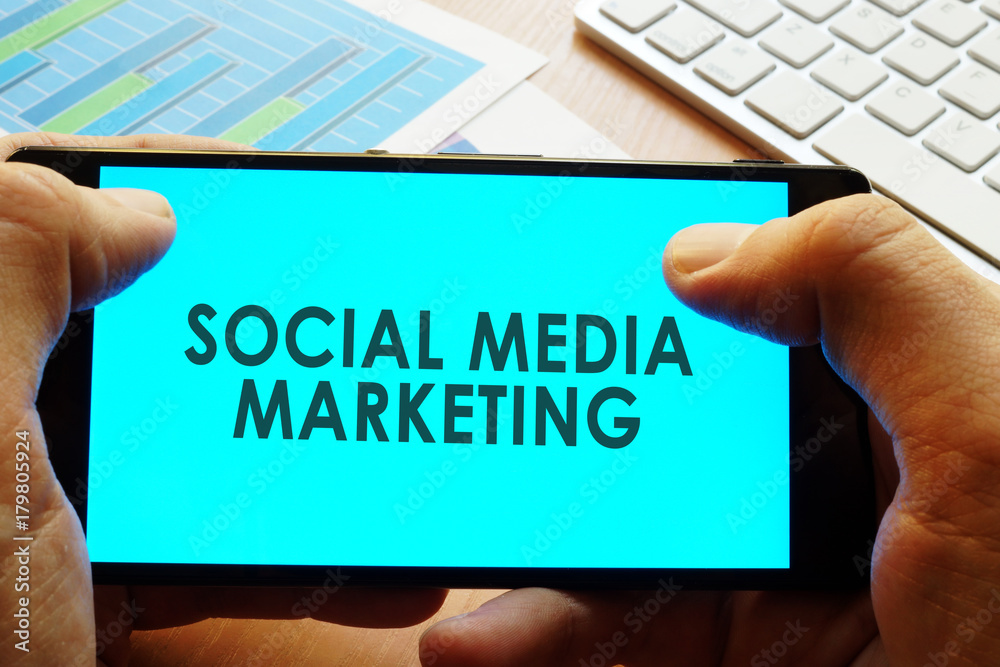 Hand holding smartphone with words social media marketing.