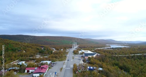 Arctic town, Cinema 4k aerial sideway view revealing utsjoki town and border bridge between norway and utsjoki town, on a cloudy autumn day, in utsjoki, Lapland, Lappi, Finland photo