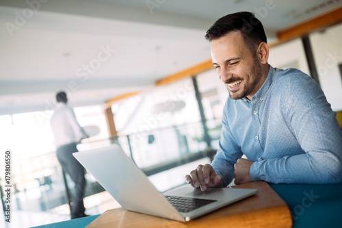 Young handsome architect working on laptop in office