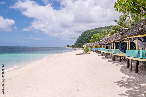 View along Lalomanu Beach, Upolu Island, Samoa, of thatched open-sided Samoan beach fale huts that are an alternative to hotel or resort accommodation photo
