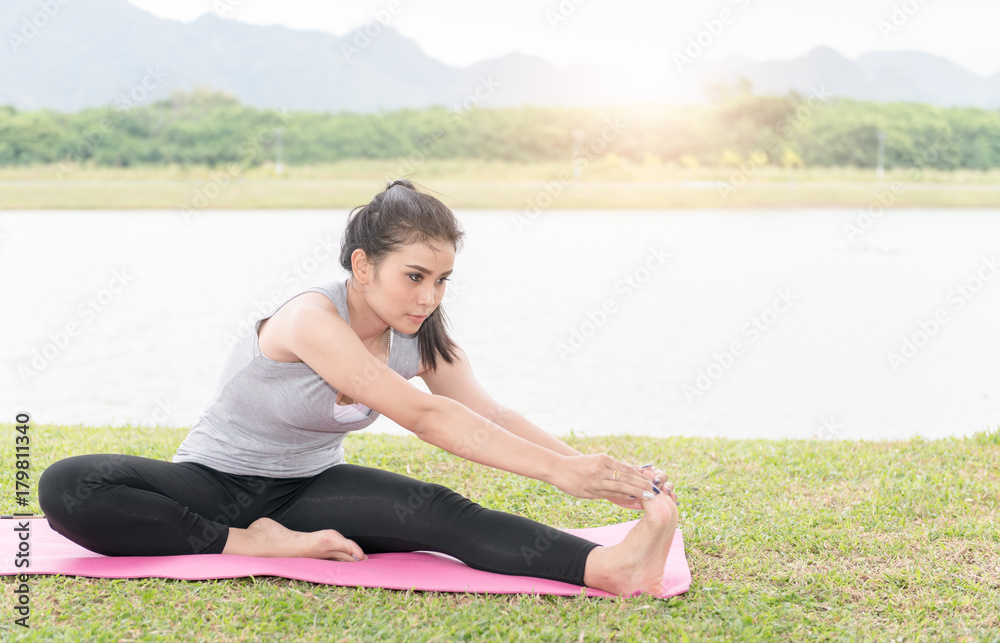 Fit asian woman stretching her leg to warm up