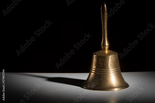 Obraz na plátně A small metallic hand bell black background