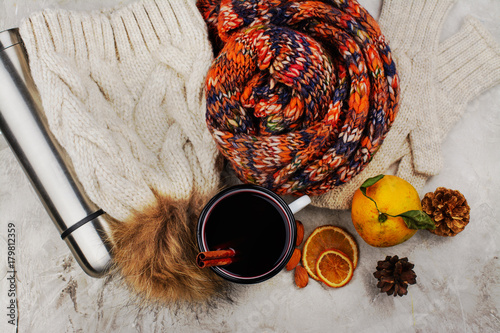 Cold weather walking set: warm clothes, hot mulled wine and thermos flask on wooden background. Healthy lifestyle concept