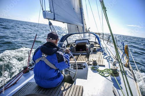 Skagen, Denmark, 31 July 2017:  A lone sailor behind the helm on the North Sea photo
