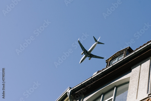 Airplane flying low above buildings, approach to landing