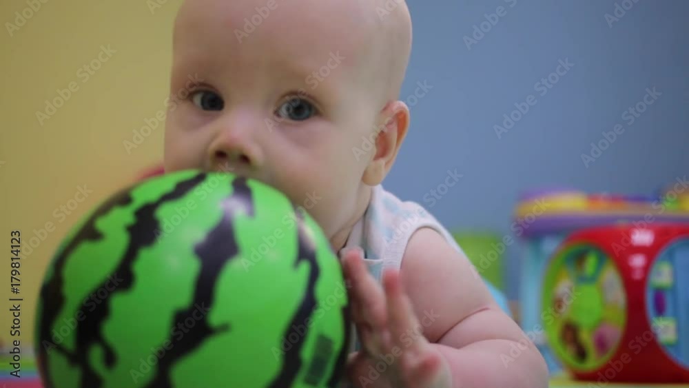little child is playing with a ball. The ball looks like a watermelon. little child is playing with a ball. The ball looks like a watermelon.