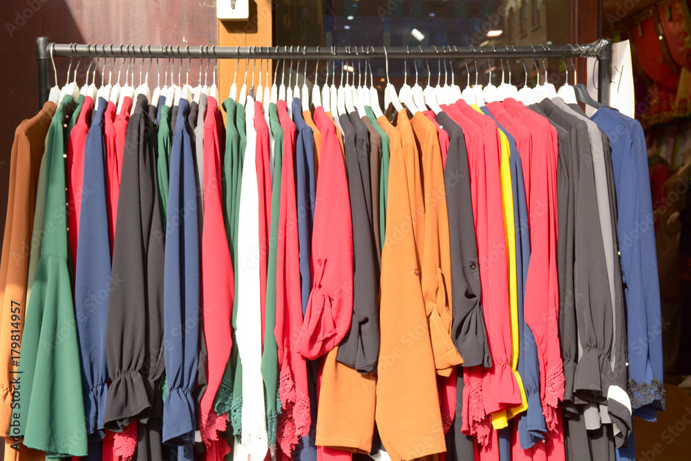Rack of colourful clothes at market stall on Mile End Road in Whitechapel London England