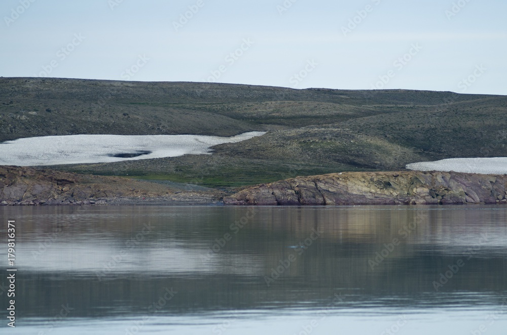 Snowy rocks of the polar island in the Arctic Ocean