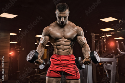 man in gym. Muscular bodybuilder guy doing exercises with barbell. Strong person. Sports background. Young athlete ready for weight lifting training.