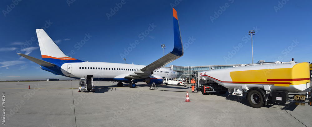 Obraz premium betanken eines Flugzeuges am Flughafen mit Kerosin - Abfertigung am Flugsteig // refuelling an aircraft at the airport with kerosene - check-in at the gate