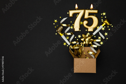 Number 75 gold celebration candle and gift box background