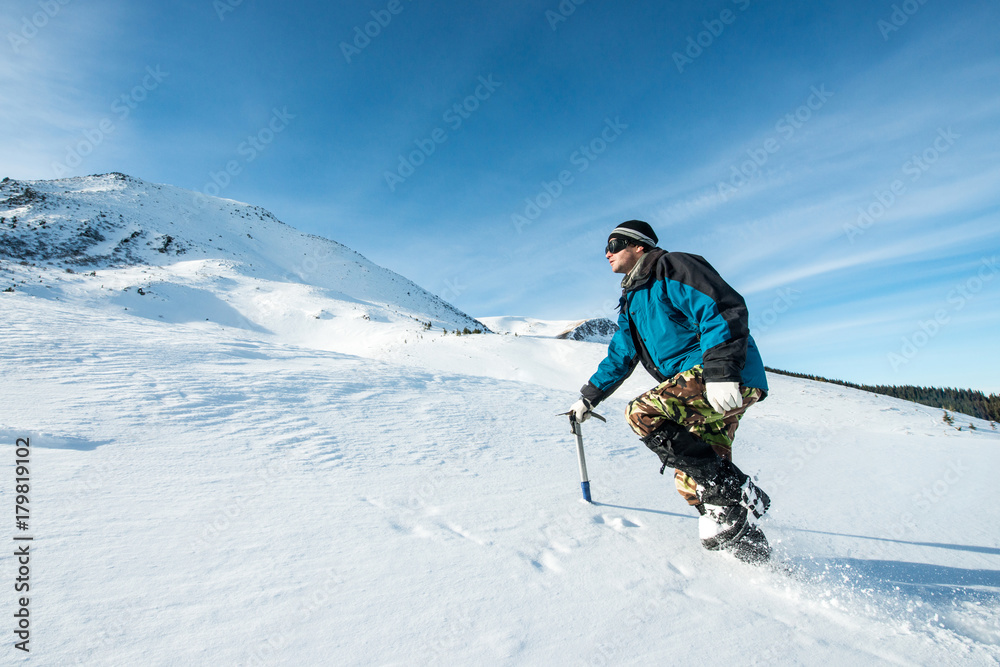 climber with an ice ax walks in the snowy mountains climber with an ice ax walks in the snowy mountains
