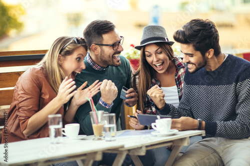Group of four friends having fun a coffee together after shopping