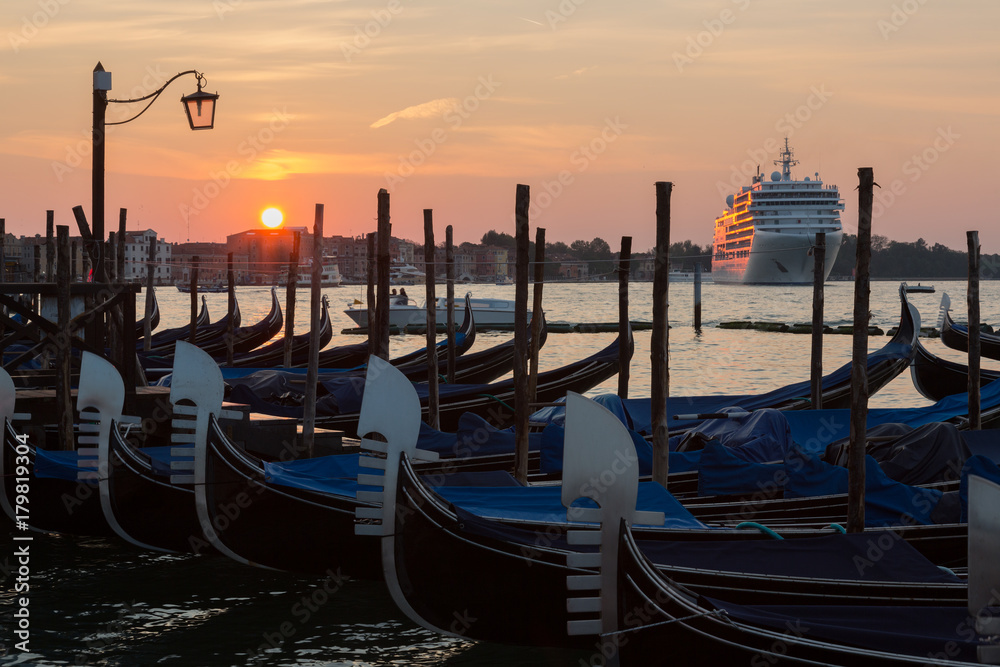 Gondolas and a large cruise ship on  Grand Canal in Venice at sunrise