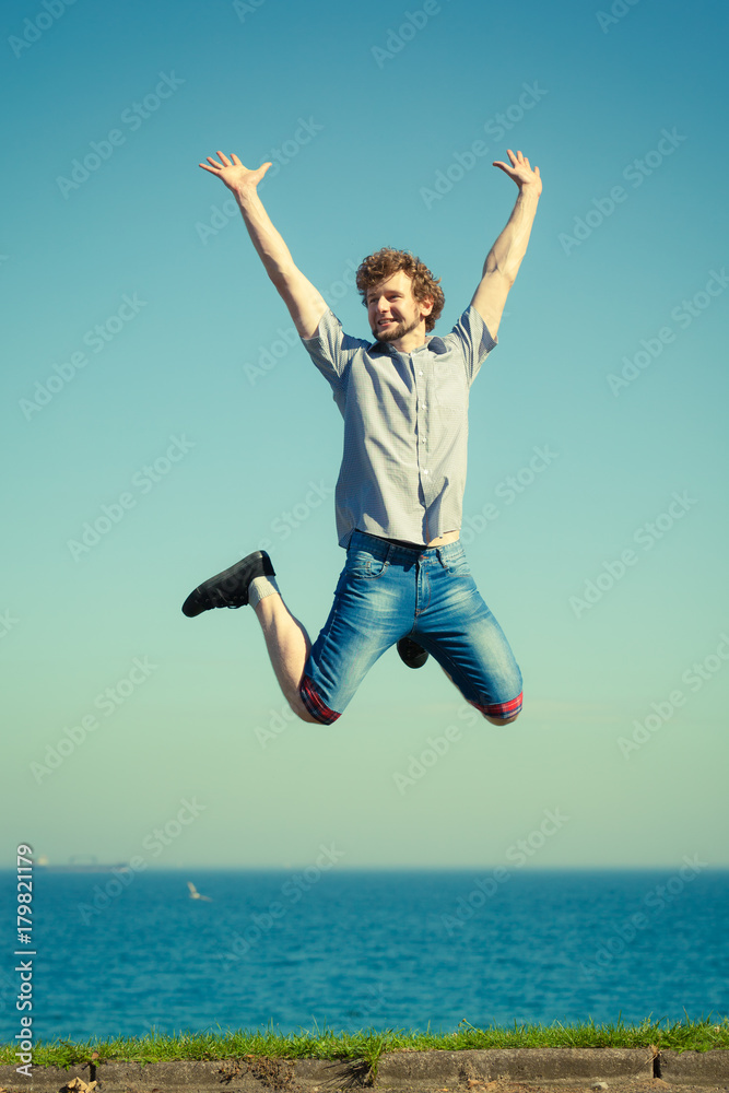 Carefree man jumping by sea ocean. Carefree man jumping by sea ocean.