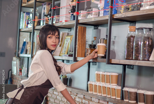 Asian women Barista is decorating a coffee shop.