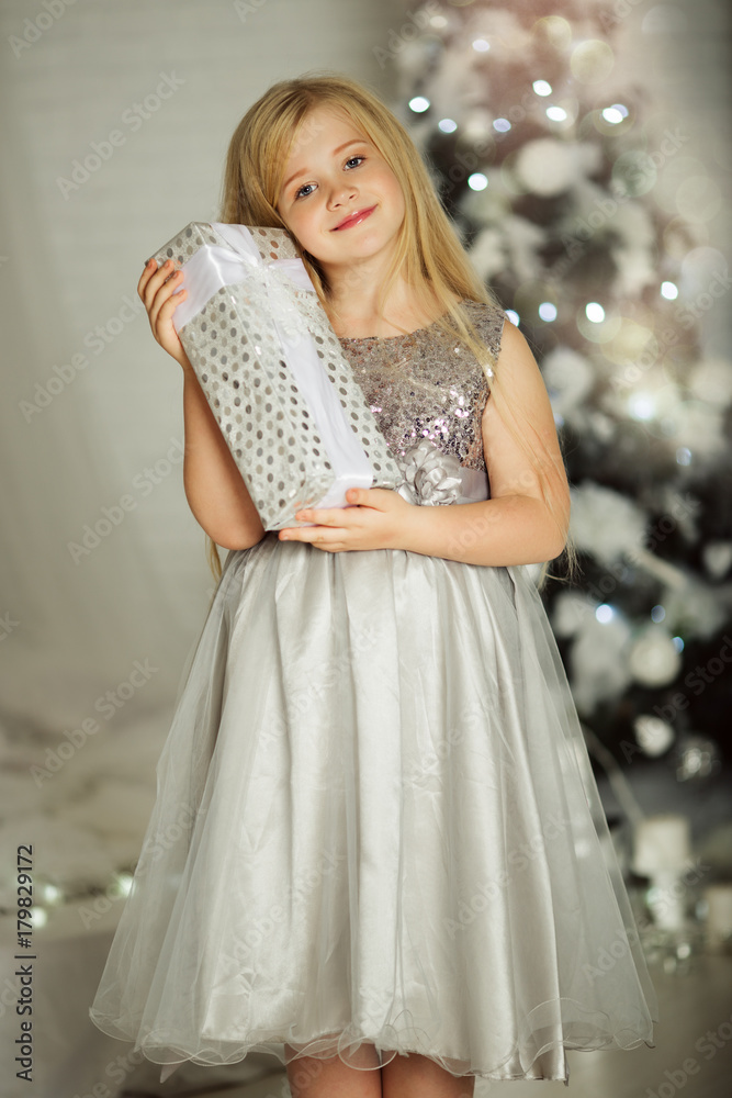 Merry Christmas and Happy Holiday. Pretty blonde girl is holding xmas gift Merry Christmas and Happy Holiday. Pretty blonde girl is holding xmas gift