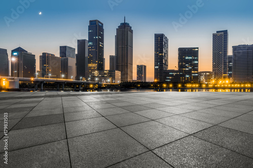 night view of empty brick floor front of the downtown skyline