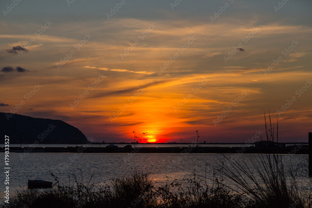sunset at lefkas lagoon in greece with dike and water
