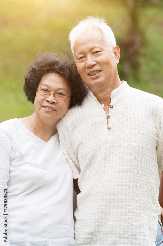 Mature Asian couple smiling outdoor.