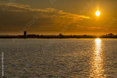 sunset at ambracian gulf in greece with lighthouse and sea photo